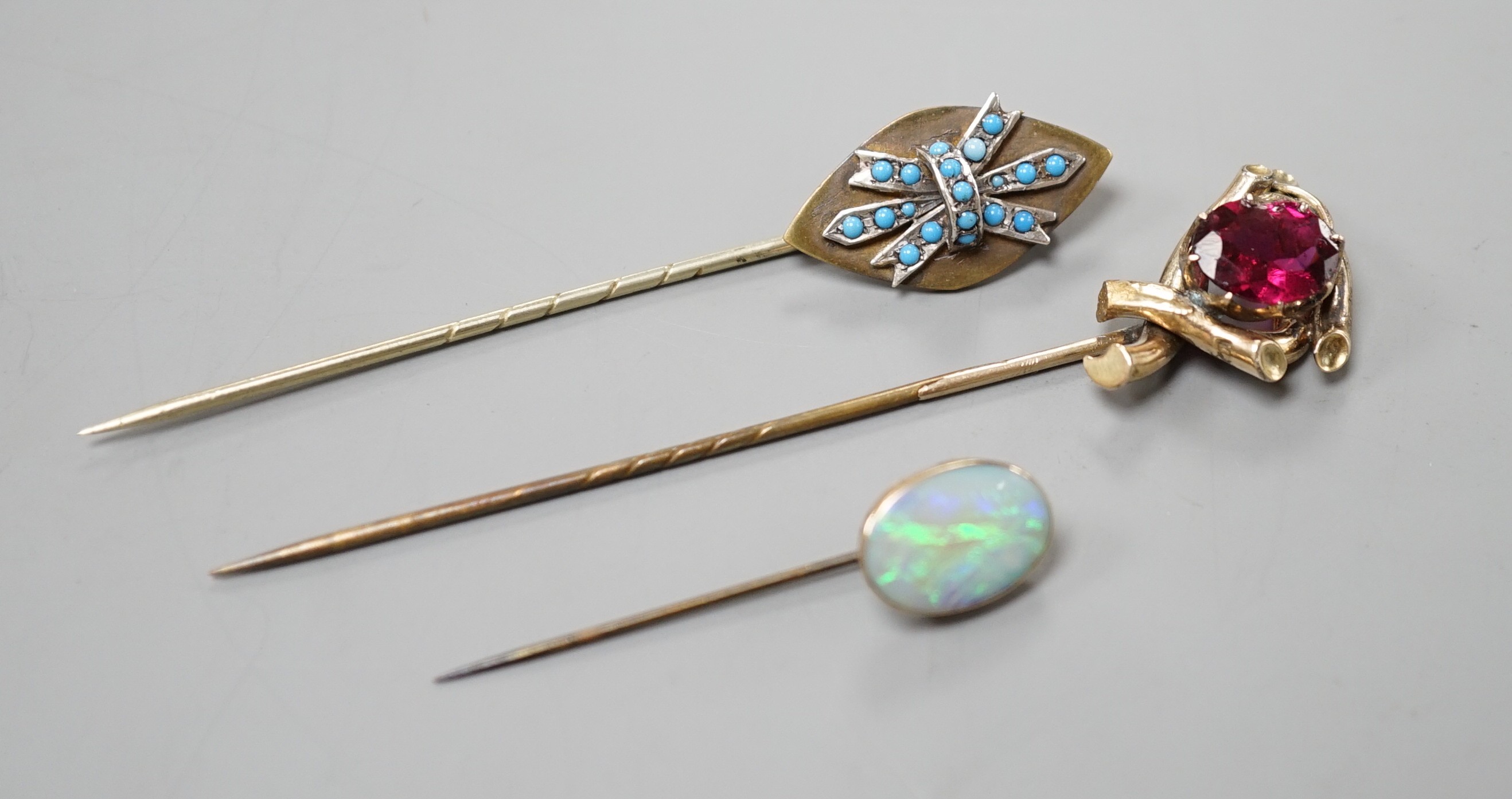 Three various base metal stick pins, one set with white opal doublet?, 45mm.